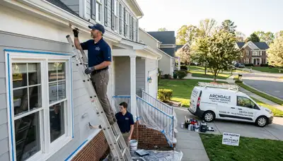 Professional house painting contractors working on a Greensboro NC home exterior