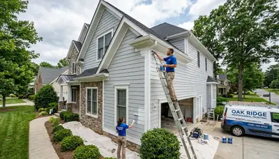 Professional house painters working on residential exterior in Greensboro, NC